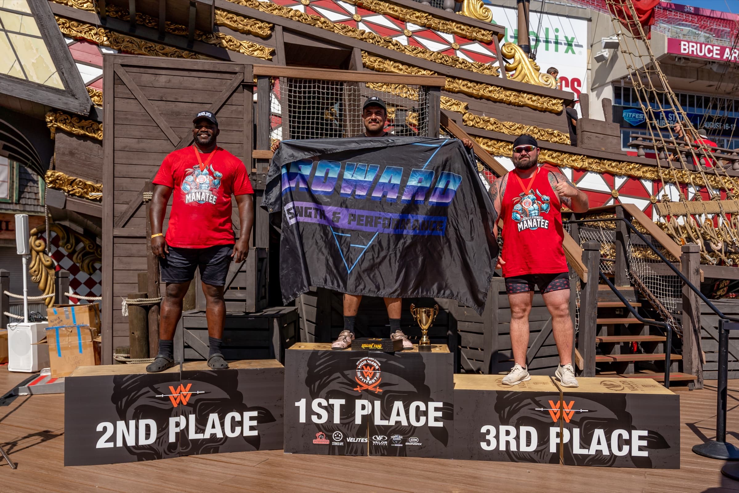 Coach Allan and Broward Strength athletes celebrating a strongman competition podium finish